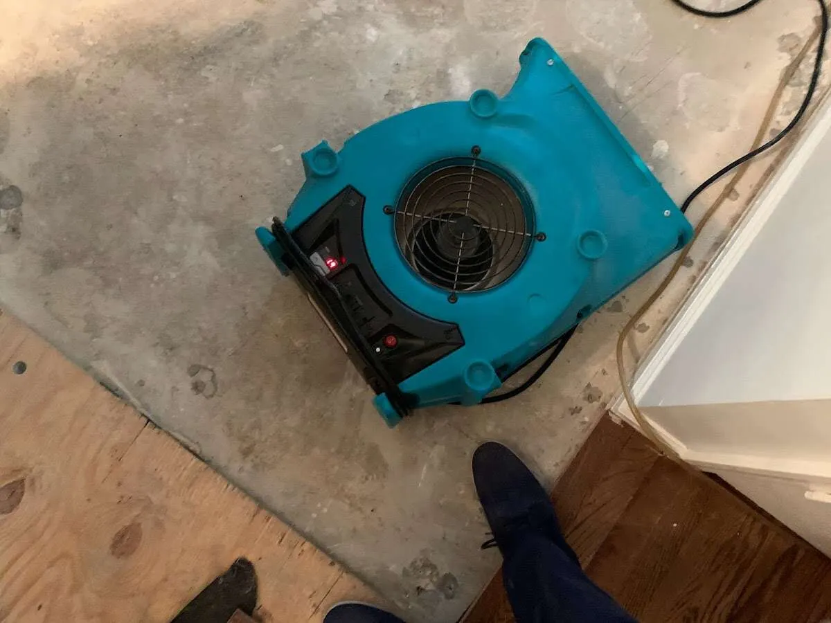Air mover drying subfloor during Commercial Water Damage Restoration in Credit River